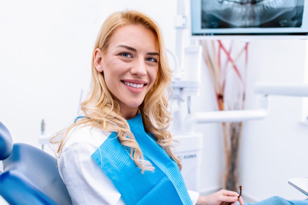 Woman smiles from dental chair