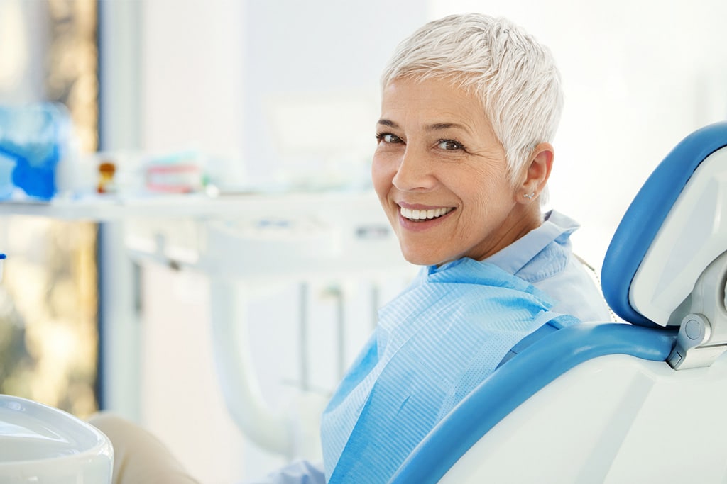 Lady in dentist chair smiling